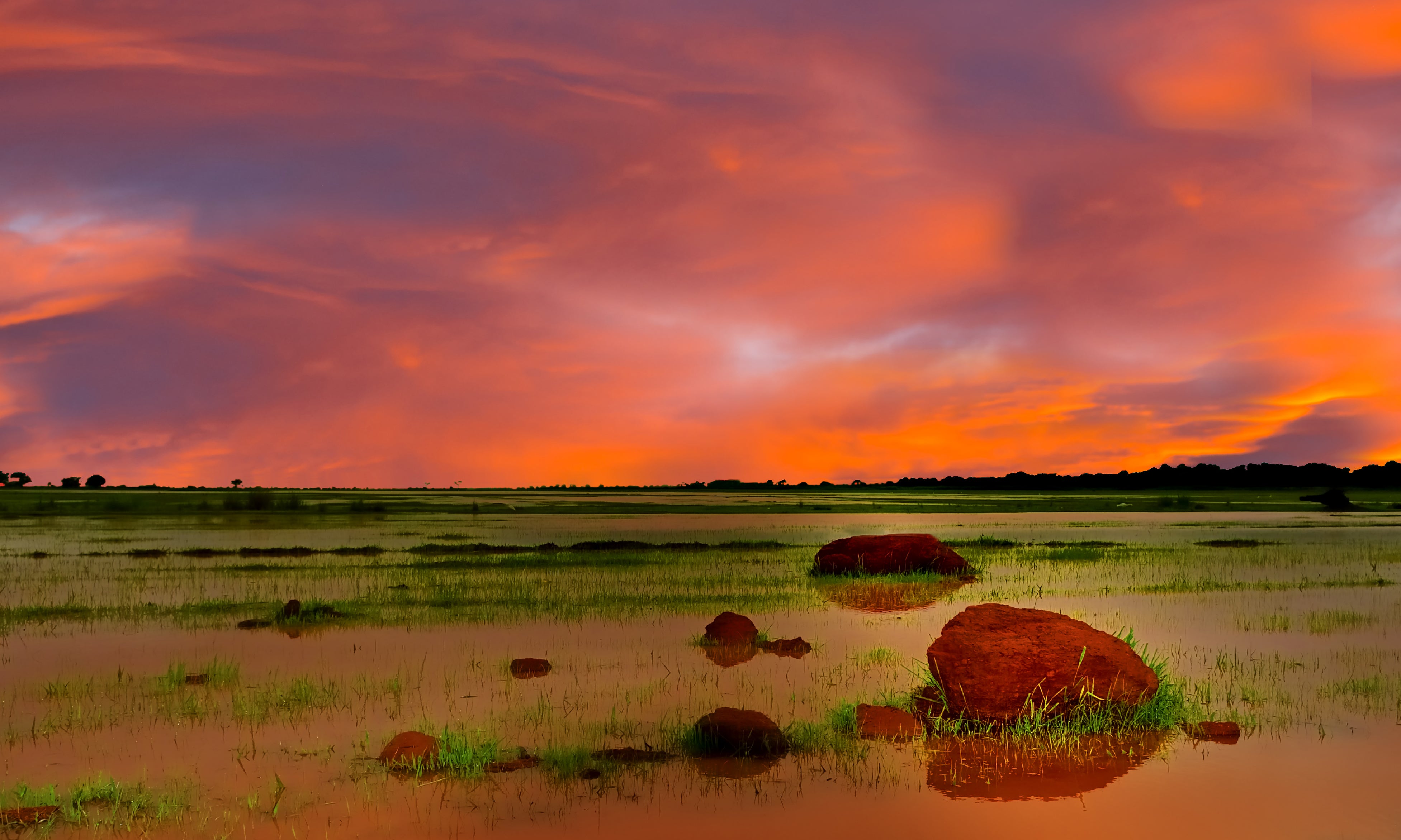 Orange sky above the Jur River wetlands near Wau, South Sudan. 'Under an African Sky' by Michael Walsh. CC BY 3.0: https://creativecommons.org/licenses/by/3.0/. Source: https://commons.wikimedia.org/wiki/File:Under_an_African_Sky_-_panoramio.jpg. Image unchanged.